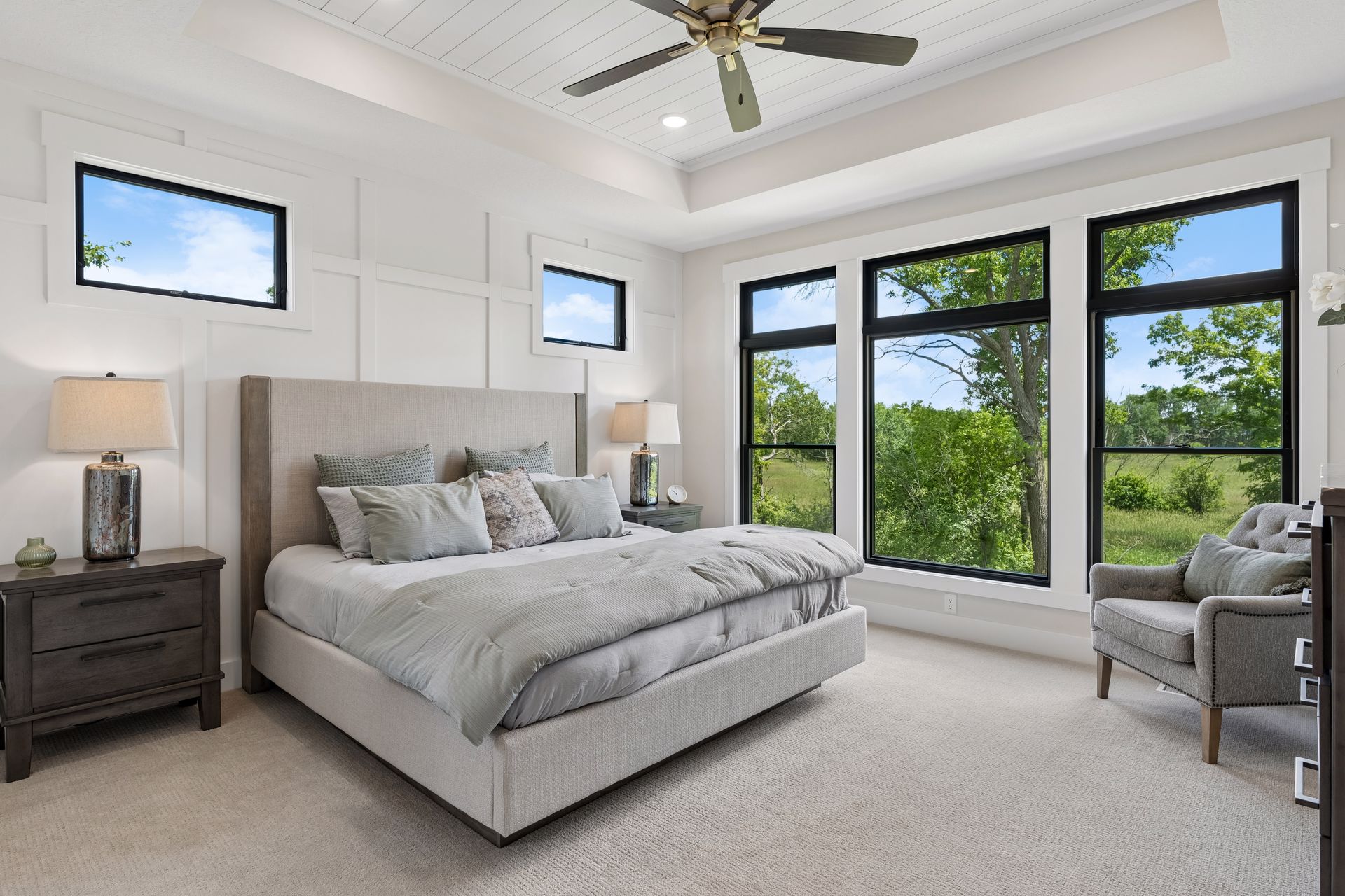 Primary bedroom suite with tray ceiling and panoramic nature views
